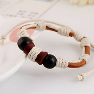 Bracelet mixte marron en cuir avec large cordon beige et perles noires distinctives.