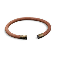 Bracelet en cuir marron avec fermoir magnétique en métal vintage, style minimaliste unisexe.