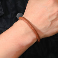 Bracelet cordon en cuir marron fin avec fermeture magnétique argentée, style épuré et mixte.