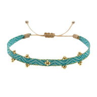 Bracelet cordon bleu en mélange polyester-coton avec perles de verre japonaises dorées, ajustable.