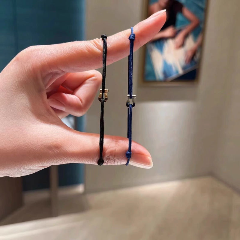 Bracelet cordon noir et bleu avec petits fers à cheval en métal doré et argenté.