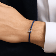 Bracelet cordon bleu avec pendentif fer à cheval en acier inoxydable porté au poignet.