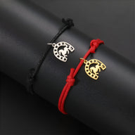 Bracelet cordon noir avec fer à cheval en acier inoxydable argenté et bracelet cordon rouge avec fer à cheval doré.