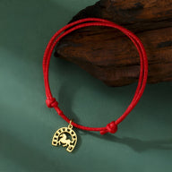 Bracelet cordon rouge avec pendentif fer à cheval en acier inoxydable doré pour femme.