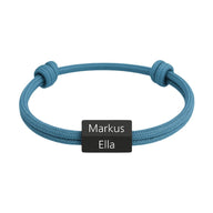 Bracelet cordon bleu avec plaque en acier inoxydable noire gravée des prénoms Markus et Ella.