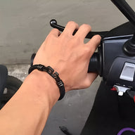 Bracelet cordon noir pour homme avec inscription "madness" en métal noir mat, style moderne et épuré.