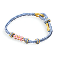 Bracelet cordon bleu avec motif floral rose et détails dorés modèle Reyna pour femme.
