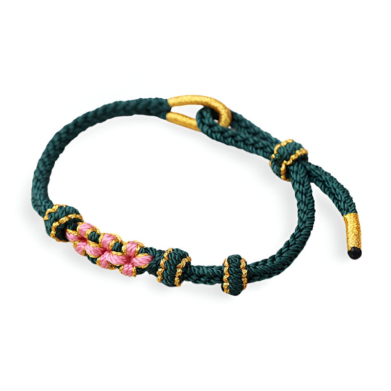 Bracelet cordon vert foncé avec motif floral rose et détails jaune or.