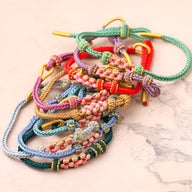 Lot de bracelets cordon colorés avec motifs floraux tissés et perles dorées, styles Reyna.