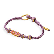 Bracelet cordon violet avec motif floral rose et jaune, fermeture nouée ajustable.