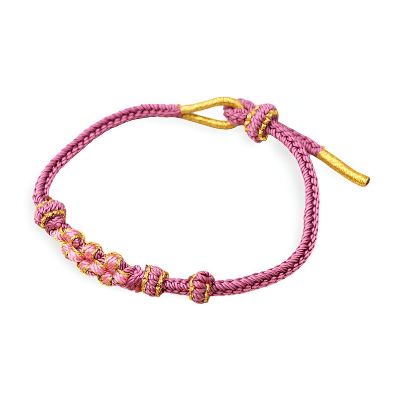 Bracelet cordon rose avec motif floral en perles dorées et détails violets, style délicat pour femme.