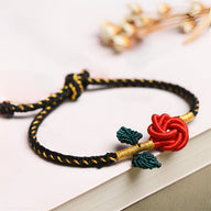 Bracelet cordon noir tressé avec motif rose éternelle rouge et feuilles vertes, modèle Sania.