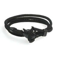 Bracelet cordon noir avec motif tortue en acier et fermeture boucle unique.