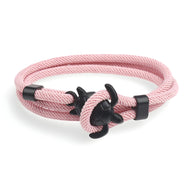 Bracelet cordon rose avec fermoir ancre noire et motif tortue en métal noir.
