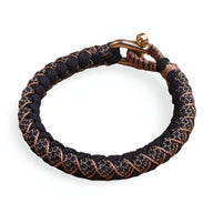Bracelet cordon en paracorde noir tacheté avec mailles brunes et fermoir mousqueton en métal bronze.