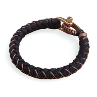 Bracelet cordon paracorde noir tressé avec fil beige et fermoir mousqueton en métal vieilli.