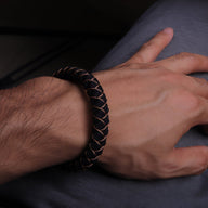 Bracelet cordon paracorde noir avec coutures beiges et fermoir mousqueton métallique.