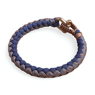 Bracelet mousqueton en paracorde bleu et beige avec tressage épais et fermoir métallique cuivré.