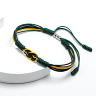 Bracelet cordon vert, jaune et noir avec nœud coulissant et perles argentées, style tressé.