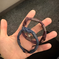 Bracelet cordon bleu indigo à petit mousqueton avec nœud et détails métalliques argentés.