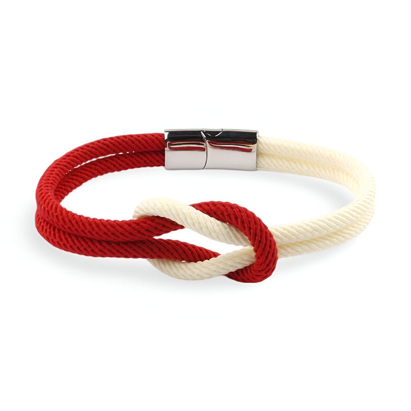 Bracelet cordon bicolore rouge et blanc avec nœud et fermoir métallique argenté.