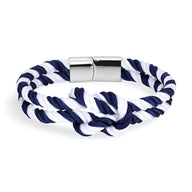 Bracelet cordon épais bleu et blanc noué avec fermoir métallique argenté.