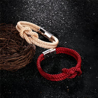 Bracelet cordon épais avec noeud, coloris crème, fermoir métal argenté élégant.