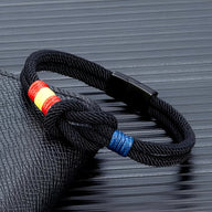 Bracelet cordon noir avec nœud et drapeau espagnol en tissu rouge, jaune et bleu.