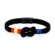 Bracelet cordon noir avec nœud central, drapeau espagnol en fil rouge et jaune, détail bleu à l'extrémité.