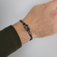 Bracelet cordon gris avec noeud central en argent sterling 925 porté au poignet.