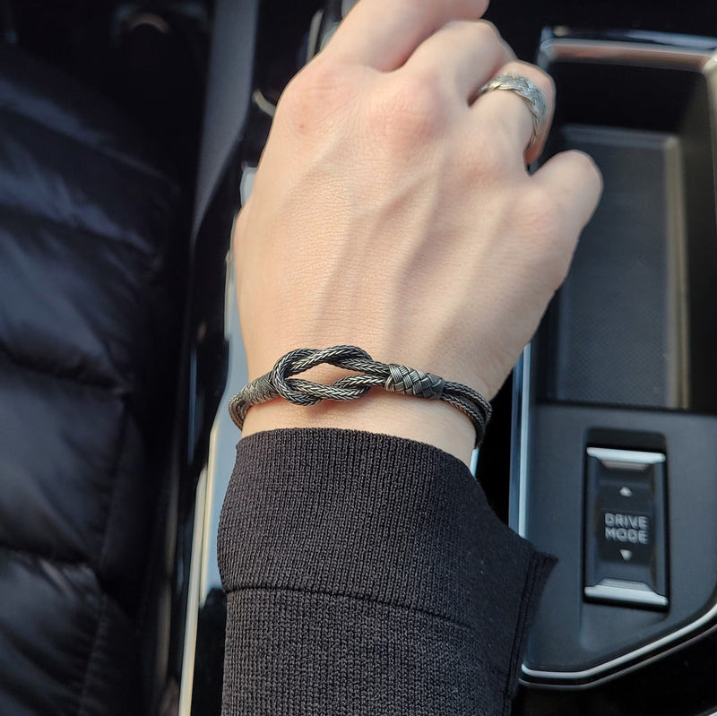 Bracelet cordon gris à noeud en argent sterling 925 porté au poignet, style unisexe élégant.