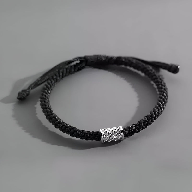 Bracelet cordon noir tressé avec ornement cylindrique en argent gravé pour homme.
