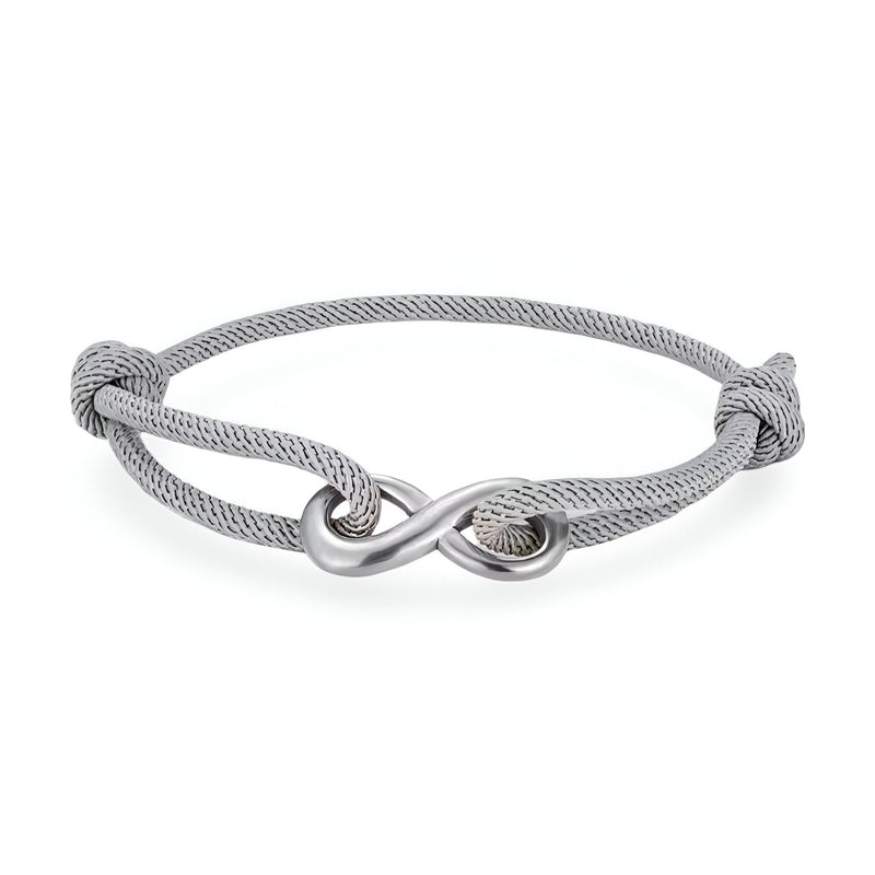 Bracelet cordon gris avec ornement infini en métal argenté, ajustable avec nœuds coulissants.