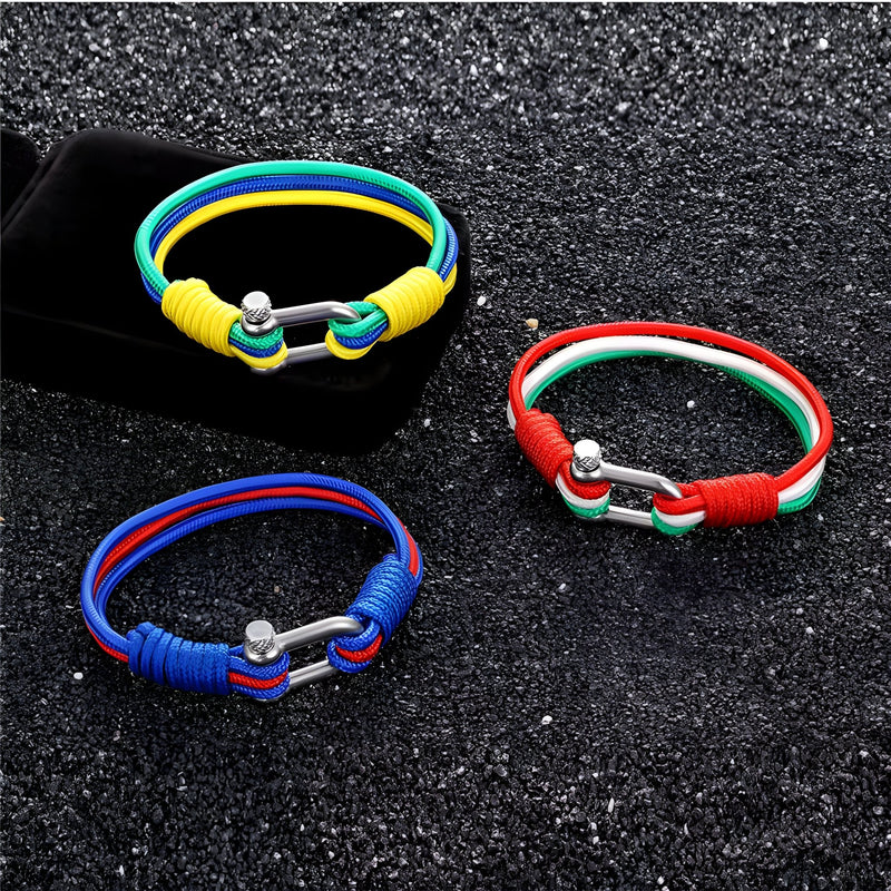 Trois bracelets cordon multicolores avec manilles en acier inoxydable sur fond noir texturé.