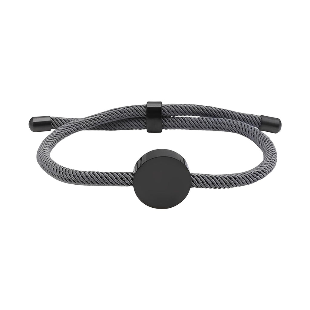 Bracelet cordon gris avec médaillon rond en acier inoxydable noir et fermoir ajustable.