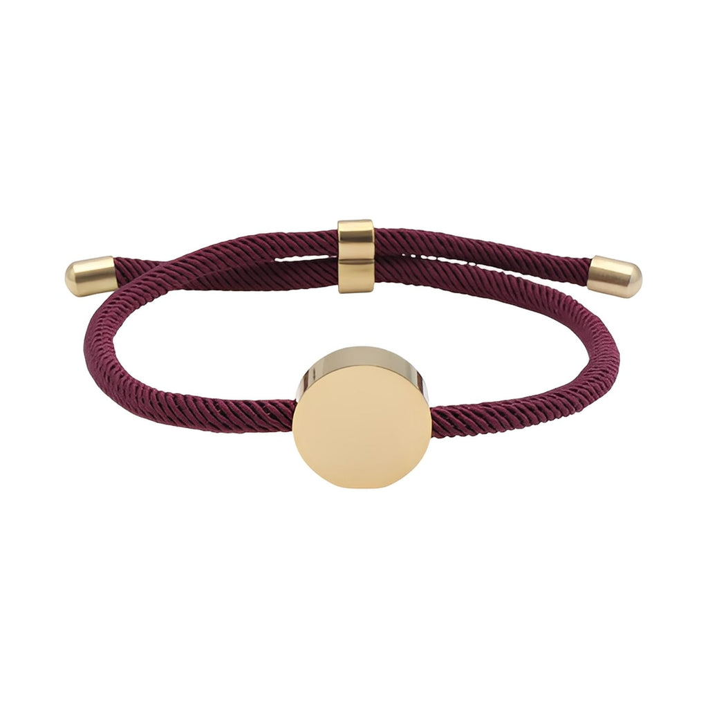 Bracelet cordon bordeaux avec médaillon rond en acier inoxydable doré, design minimaliste.