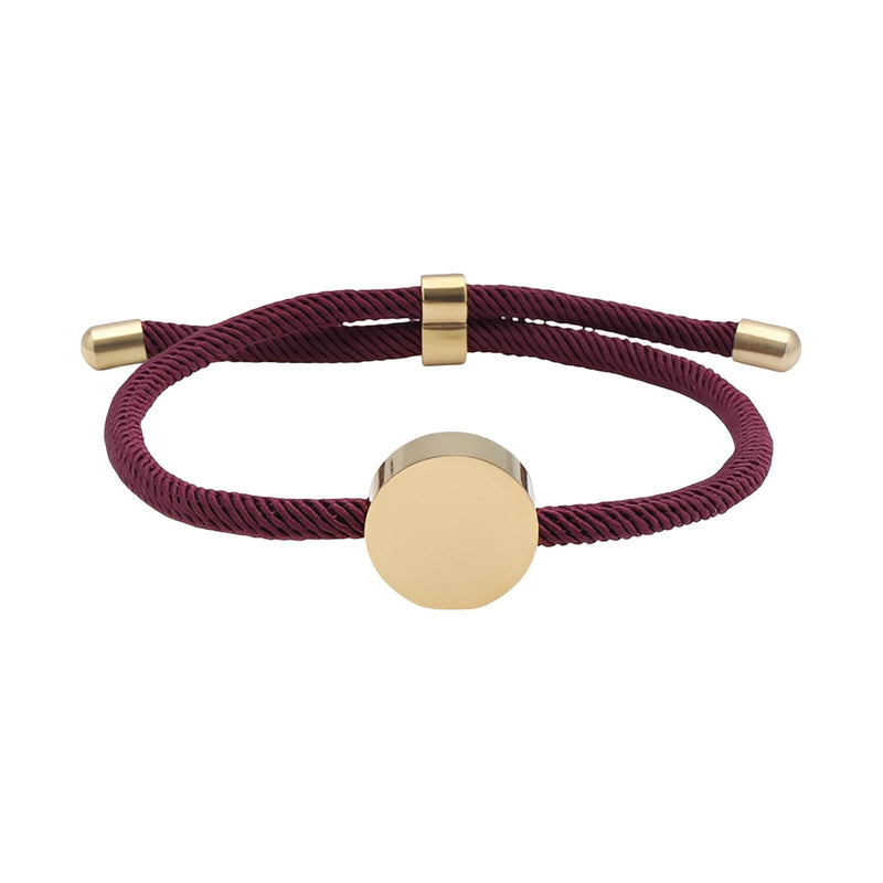Bracelet cordon bordeaux avec médaillon rond en acier inoxydable doré, design minimaliste.