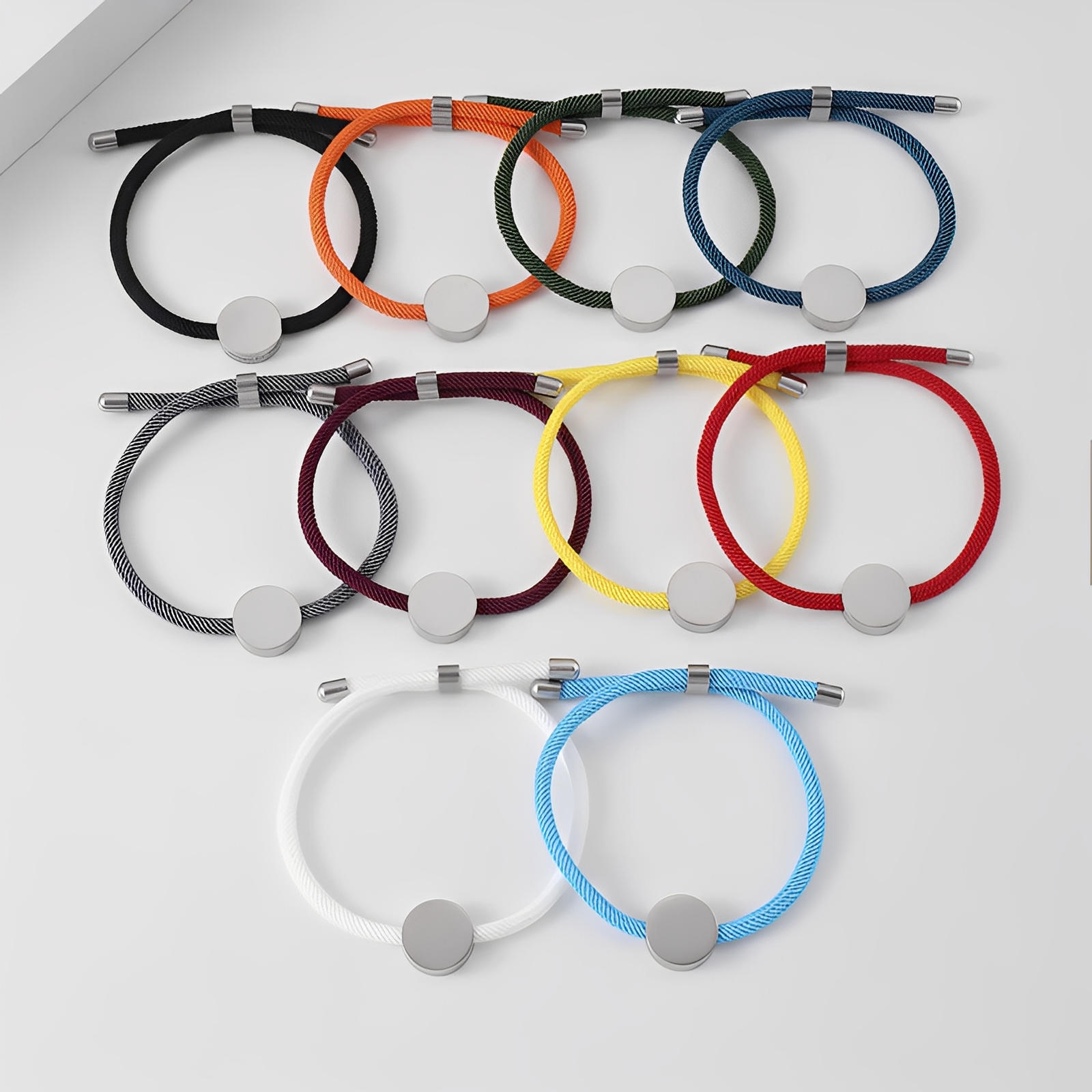 Bracelets cordon ajustables aux multiples couleurs avec médaillons ronds en acier inoxydable, pour gravure personnalisée.