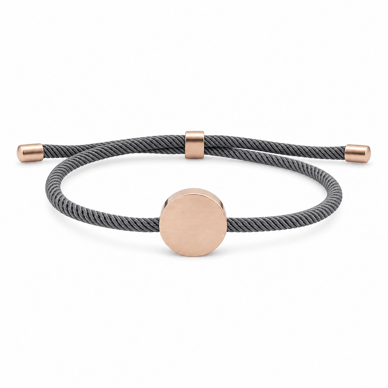 Bracelet Dax Or rosé / Gris, cordon ajustable et médaillon rond, posé de face sur fond blanc