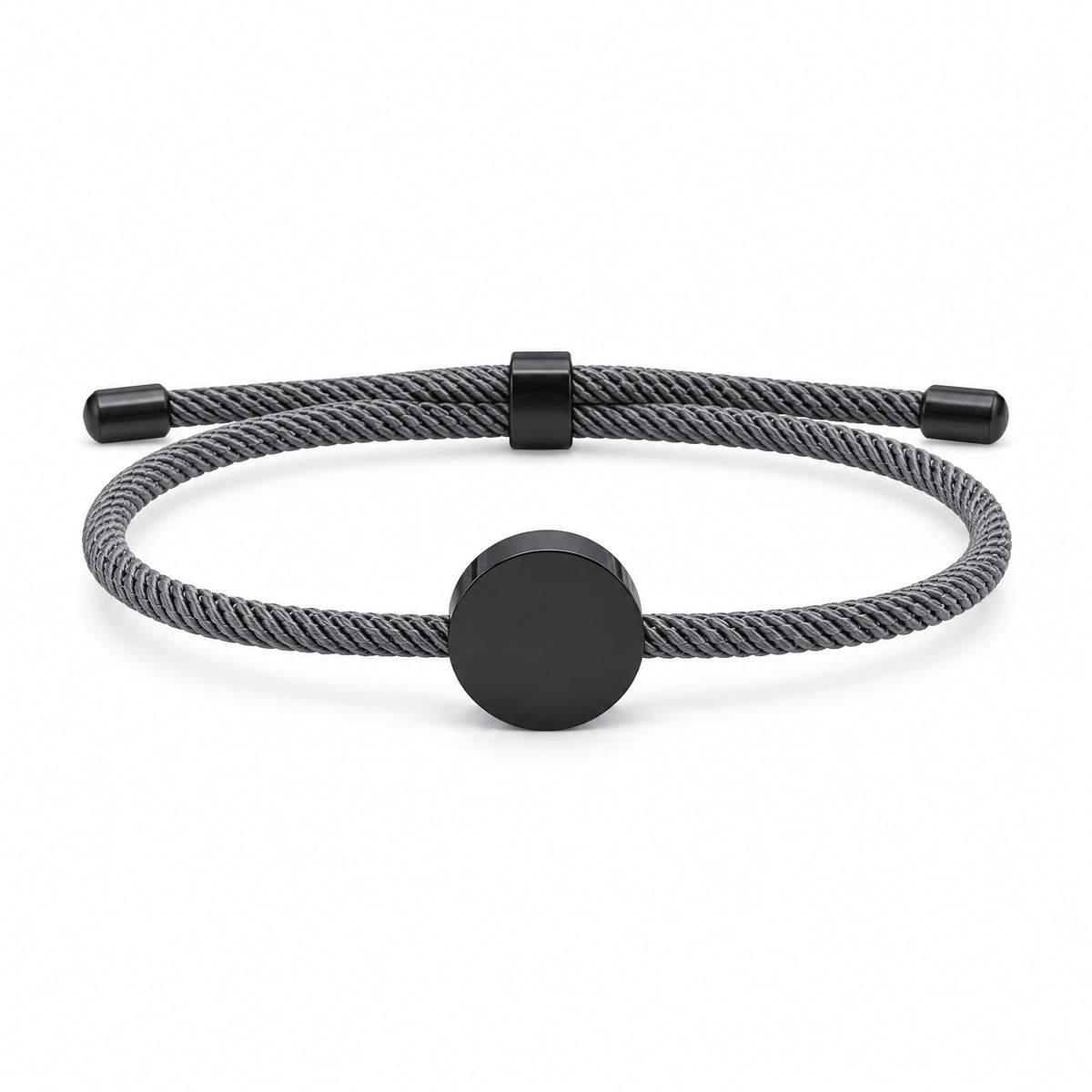 Bracelet Dax Noir / Gris, cordon ajustable et médaillon rond, posé de face sur fond blanc