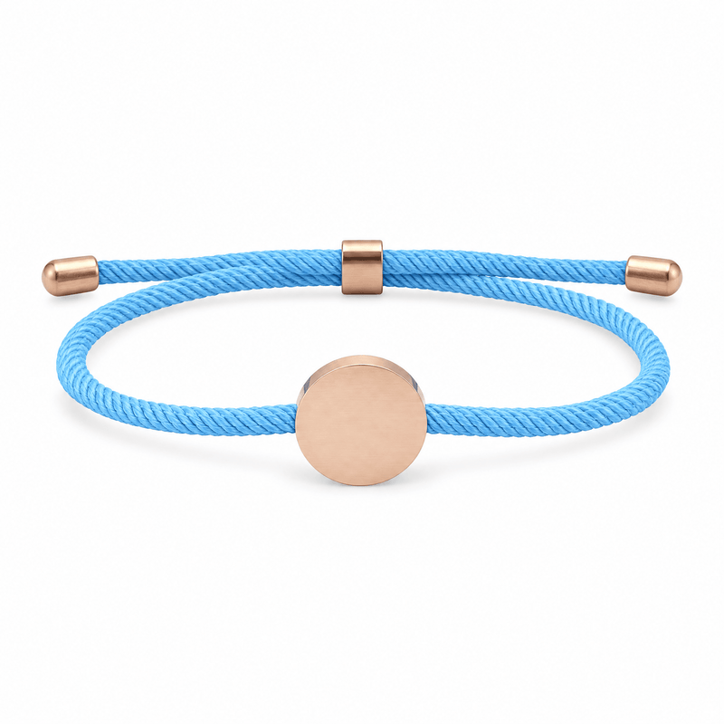Bracelet Dax Or rosé / Bleu clair, cordon ajustable et médaillon rond, posé de face sur fond blanc