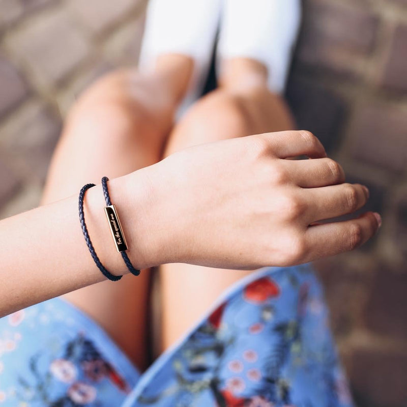 Bracelet en cuir noir tressé à enrouler, avec plaque fine métallique personnalisable, style unisexe.