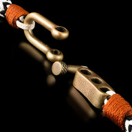 Bracelet cordon noir et blanc avec mousqueton ancien en métal vieilli et détails en cuir marron.