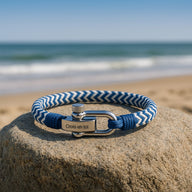 Bracelet cordon bleu et blanc à chevrons avec plaque gravée "Crois en toi" et fermoir mousqueton en métal.