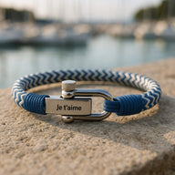Bracelet cordon bleu et blanc avec mousqueton argenté gravé "Je t'aime" sur plaque métallique.