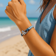 Bracelet cordon bleu et blanc avec fermoir mousqueton porté au poignet, style décontracté plage.