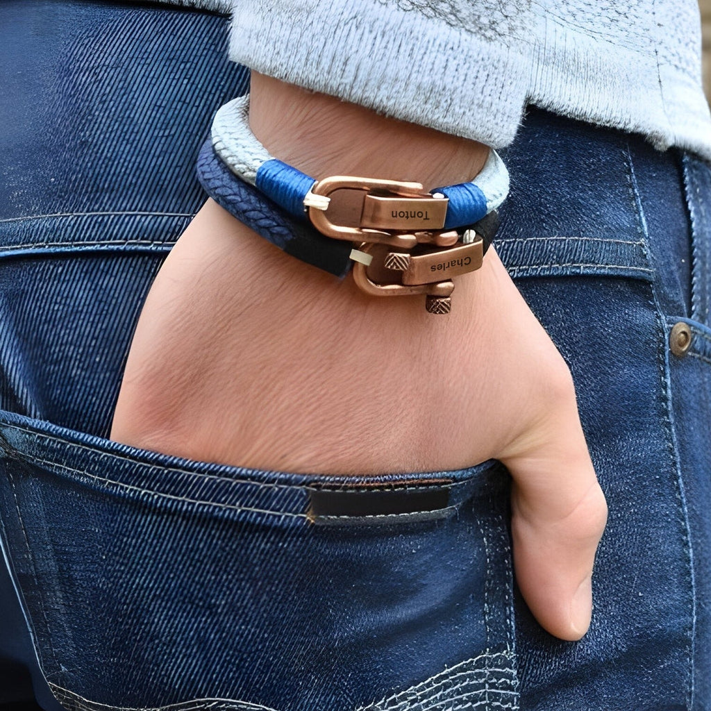 Bracelet cordon bleu et gris avec fermoir mousqueton cuivré, style homme moderne.