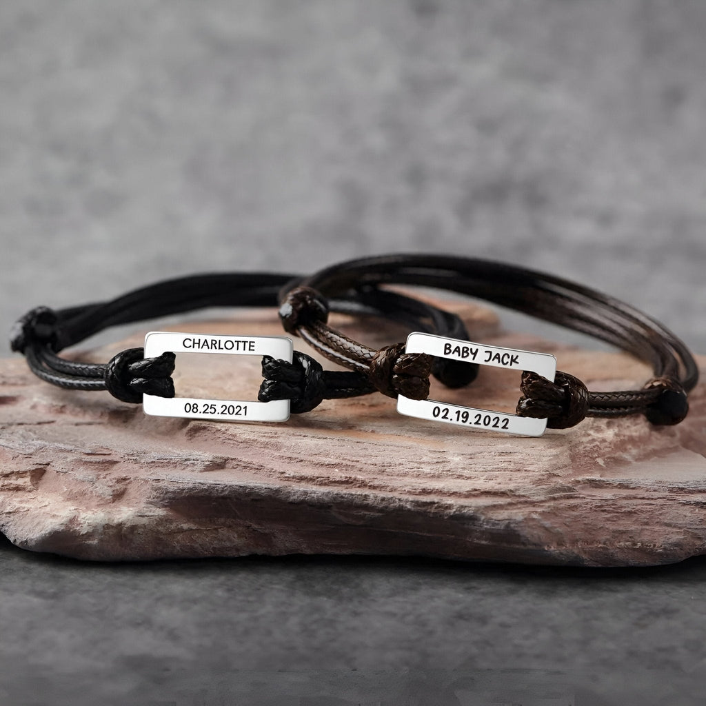 Bracelets cordon noirs avec plaques en acier personnalisées gravées de prénoms et dates, style ajustable.