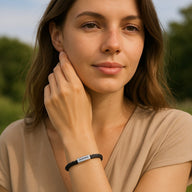 Bracelet cordon noir en cuir avec plaque personnalisée rectangulaire porté au poignet femme.