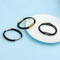 Trois bracelets cordon en cuir noir avec plaques métalliques argent, or et noir, style Horacio.